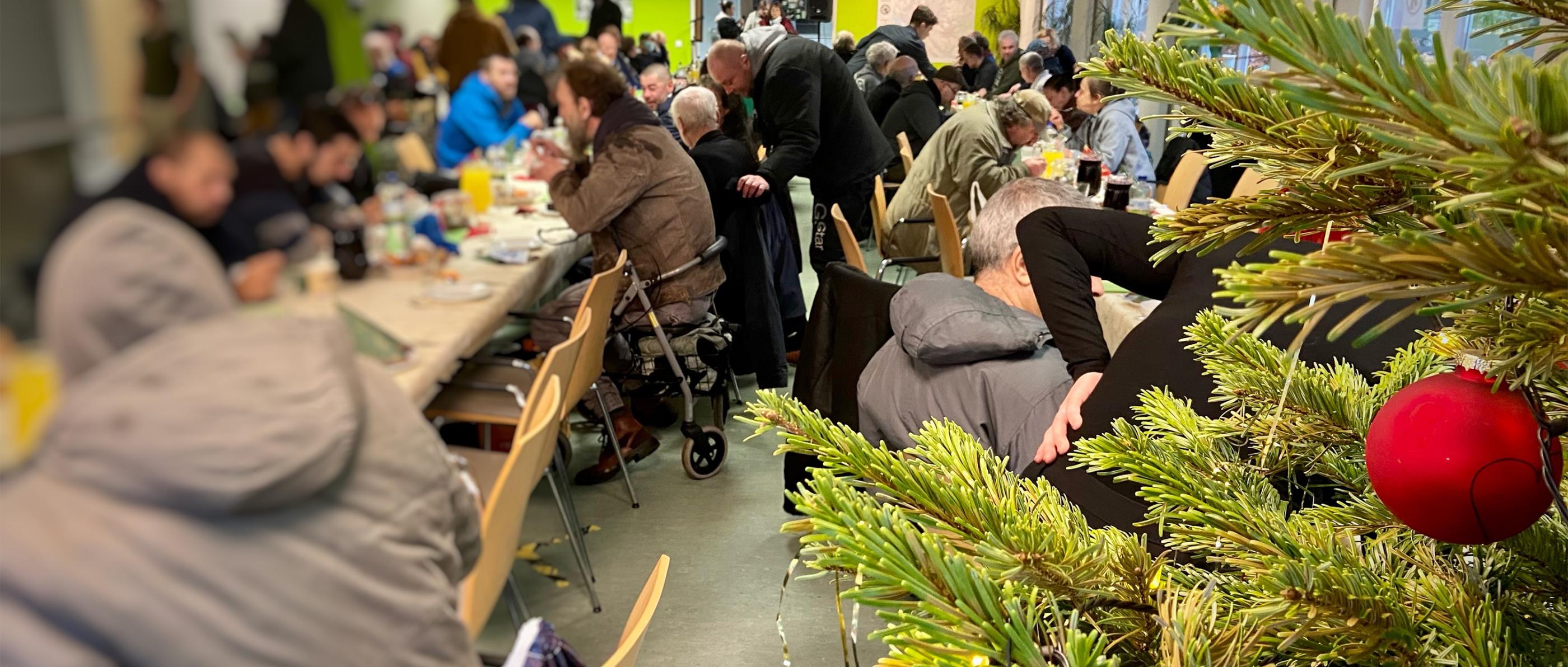 Obdachlsose sitzen beim Weihnachtsessen - Diakonie Hamburg